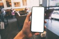 A hand holding and showing black mobile phone with blank white screen in cafe Royalty Free Stock Photo