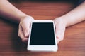 Mockup image of hands holding white mobile phone with blank black screen with hot coffee cup Royalty Free Stock Photo