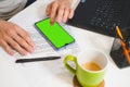 Mockup image, man hand touching blank green screen mobile smart phone, working on laptop Royalty Free Stock Photo