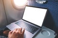 A man using and touching on laptop computer touchpad with blank white desktop screen while sitting in the cabin Royalty Free Stock Photo