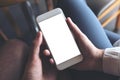 Man and woman`s hands holding and looking at white mobile phone with blank desktop screen together Royalty Free Stock Photo