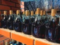 Mockup image of red wine bottles on stone shelves at local winery - traditional homemade wine or alcohol fruit drinks in local