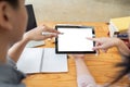 Mockup image of two student holding black tablet with blank desktop white screen while study at table in livingroom Royalty Free Stock Photo