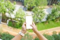 Mockup image of Woman hand holding mobile smartphones white screen for mockup design and others app display background.