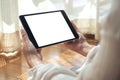 A woman holding black tablet pc with blank white desktop screen horizontally while laying down on the floor with feeling relaxed Royalty Free Stock Photo