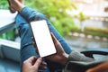 A woman holding mobile phone with blank white desktop screen while sitting in office Royalty Free Stock Photo