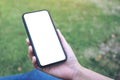 A woman holding and using black smart phone with blank white desktop screen Royalty Free Stock Photo