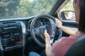 Mockup image of a woman holding and using mobile phone with blank screen while driver a car, for GPS, Lifestyles photo in car, Royalty Free Stock Photo