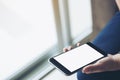 Mockup image of woman`s hand holding black mobile phone with blank white screen Royalty Free Stock Photo