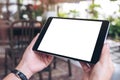 Woman`s hands holding black tablet pc with blank screen horizontally in cafe Royalty Free Stock Photo