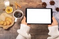 Mockup image of woman`s hands holding black tablet pc with white blank screen, coffee cup on wooden table. Top view Royalty Free Stock Photo