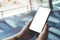 A woman`s hands holding and using black mobile phone with blank screen while sitting in the airport Royalty Free Stock Photo