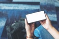 A woman`s hands holding and using black mobile phone with blank screen while sitting in the airport Royalty Free Stock Photo