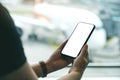 A woman`s hands holding and using black mobile phone with blank screen while sitting in the airport Royalty Free Stock Photo