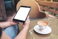 woman's hands holding black tablet pc with blank white screen with coffee cup on wooden table in cafe Royalty Free Stock Photo