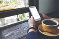 Mockup image of woman`s hands holding white mobile phone with blank screen and yellow coffee cup Royalty Free Stock Photo