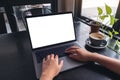 A woman`s hands using and typing on laptop with blank white desktop screen with coffee cup on wooden table in cafe Royalty Free Stock Photo