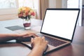 Mockup image of woman`s hands using and typing on laptop with blank white desktop screen on wooden table Royalty Free Stock Photo