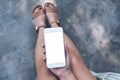 Mockup image of a woman sitting crossed leg and holding white mobile phone with blank desktop screen with concrete floor Royalty Free Stock Photo