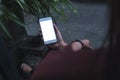 Mockup image of a woman sitting crossed leg and holding white mobile phone with blank screen with concrete floor Royalty Free Stock Photo