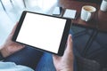 A woman sitting and holding black tablet pc with blank white desktop screen horizontally Royalty Free Stock Photo