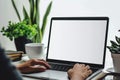 Mockup image of a woman using laptop and presenting with blank white screen for advertising text Royalty Free Stock Photo