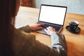 A woman using and typing on laptop computer with blank white desktop screen in cafe Royalty Free Stock Photo