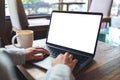 a woman using and typing on laptop computer keyboard with blank white desktop screen Royalty Free Stock Photo