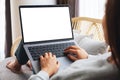 A woman working and typing on laptop computer with blank screen while sitting on a sofa at home Royalty Free Stock Photo