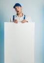 Mockup image of a young indignant worker holding empty white banner. White or blue background. Bussines concept