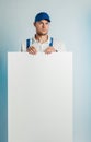 Mockup image of a young indignant worker holding empty white banner. White or blue background. Bussines concept