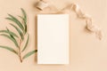 Mockup invitation, blank greeting card and green leaves eucalyptus. Flat lay, top view.