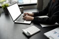 Mockup laptop, blank screen. Woman accountant using calculator and laptop in office Royalty Free Stock Photo