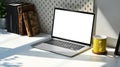 Laptop computer with empty display, coffee cup and books on white table. Home office workplace concept. Royalty Free Stock Photo