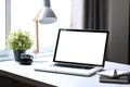 Laptop computer, potted plant, coffee cup and lamp on white table in bright home office. Royalty Free Stock Photo