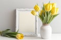 Mockup with a light background and yellow tulips in a vase in a white frame Royalty Free Stock Photo