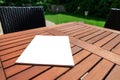 Mockup of a magazine cover on a wooden table in the garden in summer Royalty Free Stock Photo
