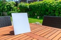 Mockup of a magazine cover on a wooden table in the garden in summer Royalty Free Stock Photo