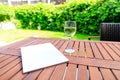 Mockup of a magazine cover on a wooden table in the garden in summer Royalty Free Stock Photo