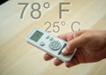 Mockup man hand holding Air conditioner remote controller above wooden background inside the house. Air conditioner with remote co Royalty Free Stock Photo