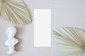 Mockup menu card with leaf palm and the statue on the nude fabric