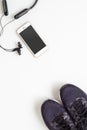 Mockup mobile cellphone with wireless bluetooth earphone and running shoes on white background. Healthy active lifestyles Royalty Free Stock Photo