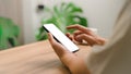 Mockup mobile phone. Adult man holding and using smartphone with blank desktop screen while working and drinking coffee in cafe