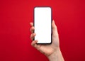 Mockup of mobile phone in hand, bright red colored background, copy space photo Royalty Free Stock Photo