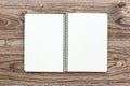 Mockup of open notepad with blank pages on wooden background.