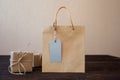 Mockup Paper bag from kraft paper with gift tag and Christmas gift boxes on a wooden background Royalty Free Stock Photo