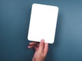 Mockup paper holding with the right hand. Hand holds the white blank mock-up white paper with a rounded corner. Royalty Free Stock Photo