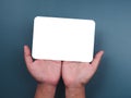 Mockup paper holding with two hands. Hands hold the white blank mock-up white paper with a rounded corner and a vertical style. Royalty Free Stock Photo