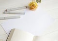 Mockup for A4 paper with single rose, book and drawing material Royalty Free Stock Photo