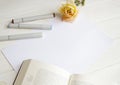 Mockup for A4 paper with single rose, book and drawing material Royalty Free Stock Photo